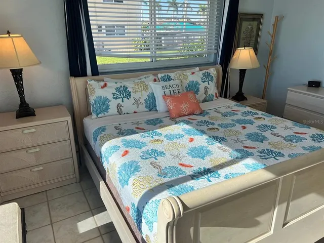 a bedroom with a bed and large windows