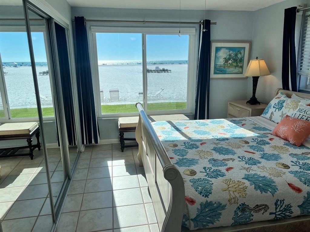 6006 Midnight Pass Road, Unit 40 Sarasota, FL 34242 - Photo 8 of 25 a bedroom with a bed and large windows