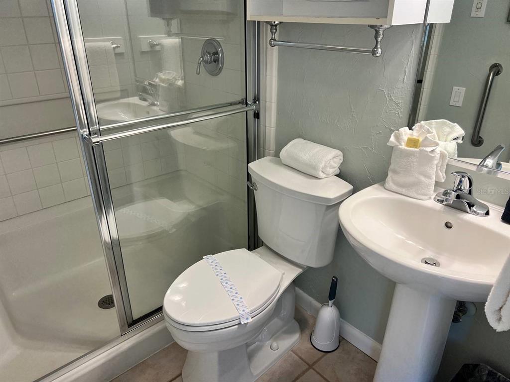 6006 Midnight Pass Road, Unit 40 Sarasota, FL 34242 - Photo 9 of 25 a white toilet sitting next to a bath tub