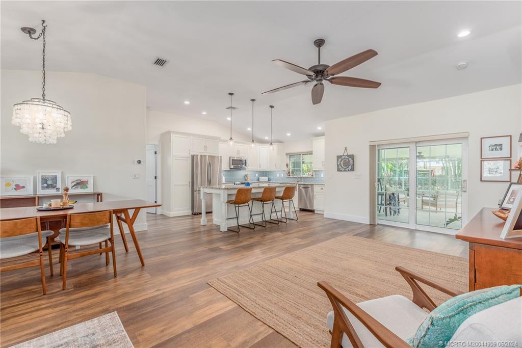 526 Southwest Rustic Circle Stuart, FL 34997 - Photo 8 of 31 a living room with furniture a table and kitchen view