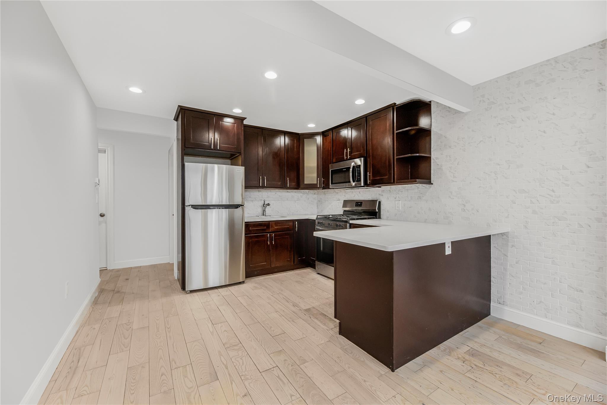 3067 Williamsbridge Road Bronx, NY 10467 - Photo 6 of 29 a kitchen with stainless steel appliances kitchen island granite countertop a refrigerator and a stove top oven