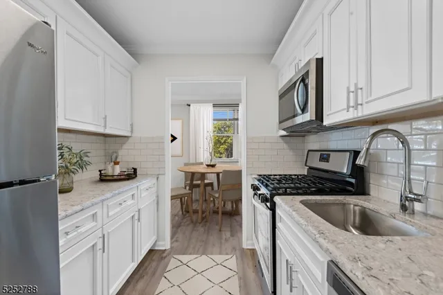 a kitchen with granite countertop a sink stove and cabinets