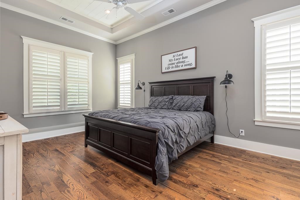 328 Washington Street Collierville, TN 38017 - Photo 14 of 33 Bedroom featuring a tray ceiling with a fan, wood-finish flooring, and white plantation shutters on multiple windows