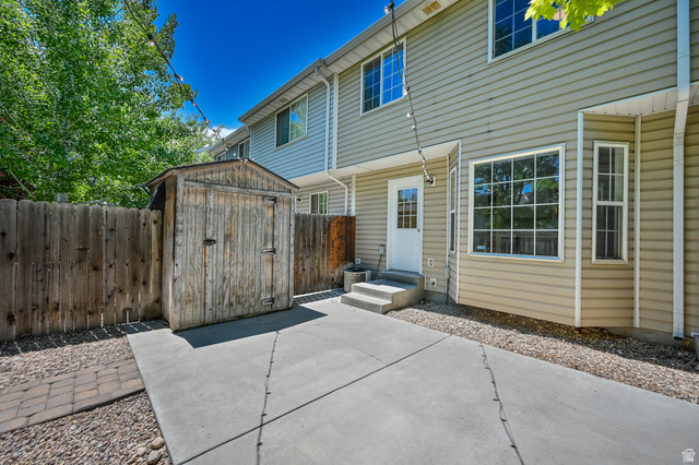 1799 West 1110th Street North Provo, UT 84604 - Photo 22 of 24 Rear exterior featuring beige horizontal siding, a white paneled door with glass inserts, and multiple windows