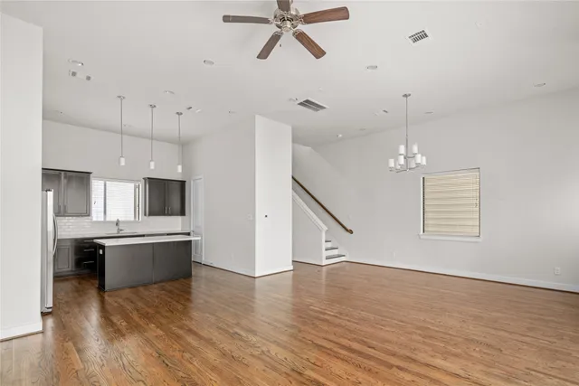 a kitchen with kitchen island a stove a sink and wooden floor
