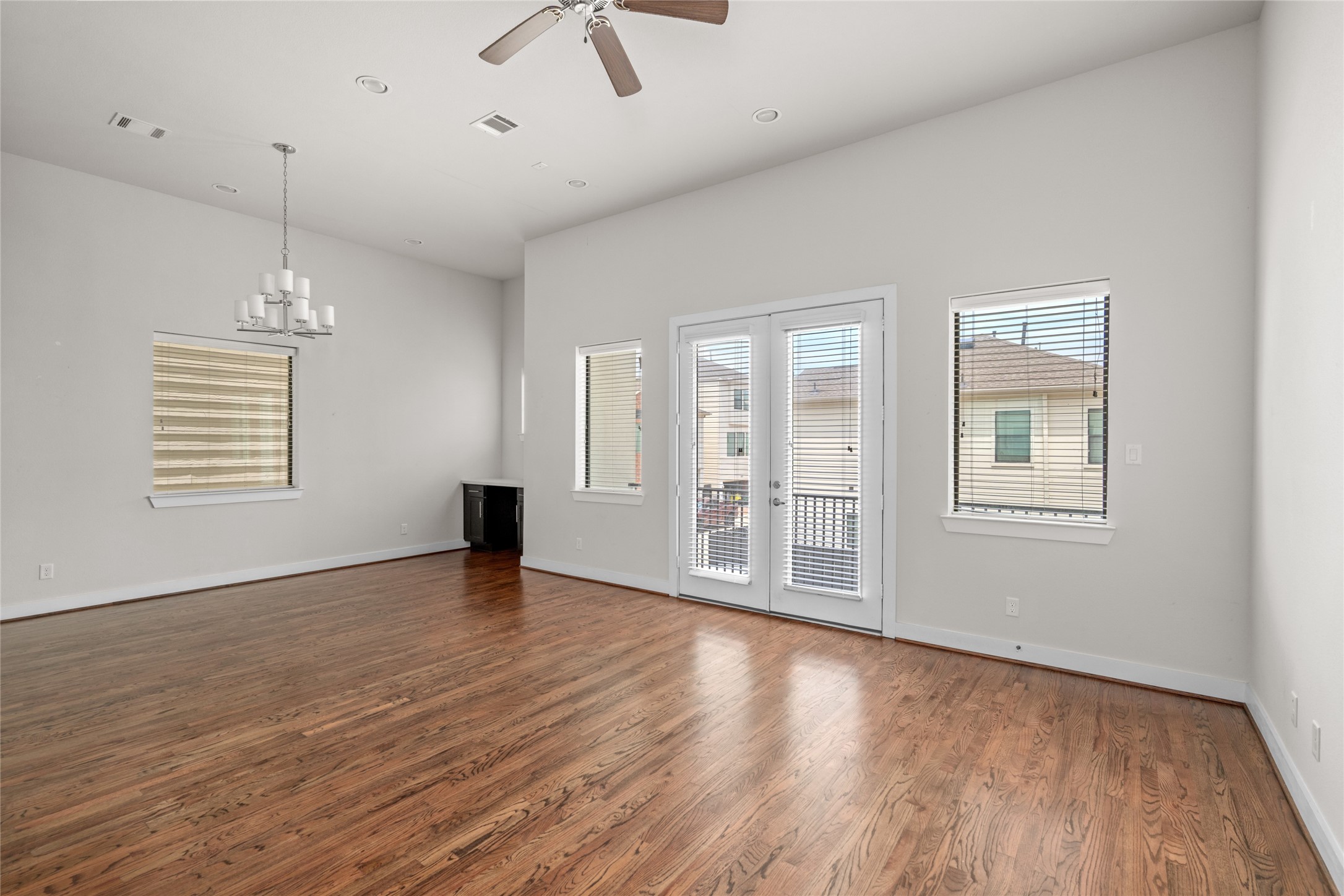 3409 Kensington Yellow Place Houston, TX 77008 - Photo 13 of 28 an empty room with wooden floor chandelier fan and windows