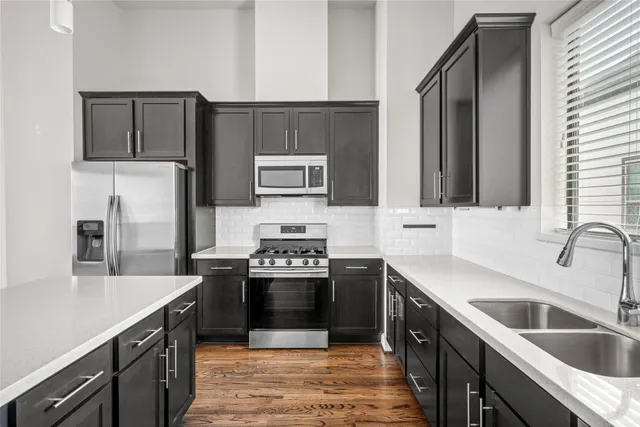 a kitchen with stainless steel appliances granite countertop a sink stove and refrigerator