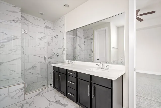 a bathroom with a sink shower and a mirror