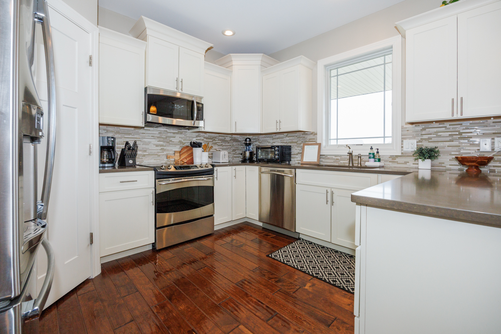 114 Mallard Way Hudson, IL 61748 - Photo 14 of 65 a kitchen with stainless steel appliances a sink a stove a microwave and cabinets