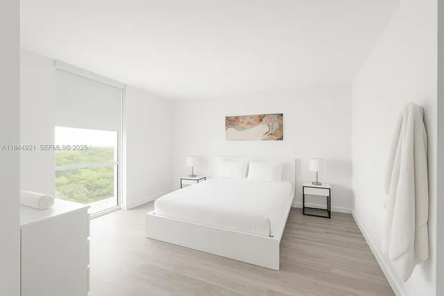 a bedroom with a bed and a large window