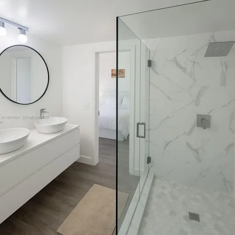 a bathroom with a double vanity sink toilet mirror and shower