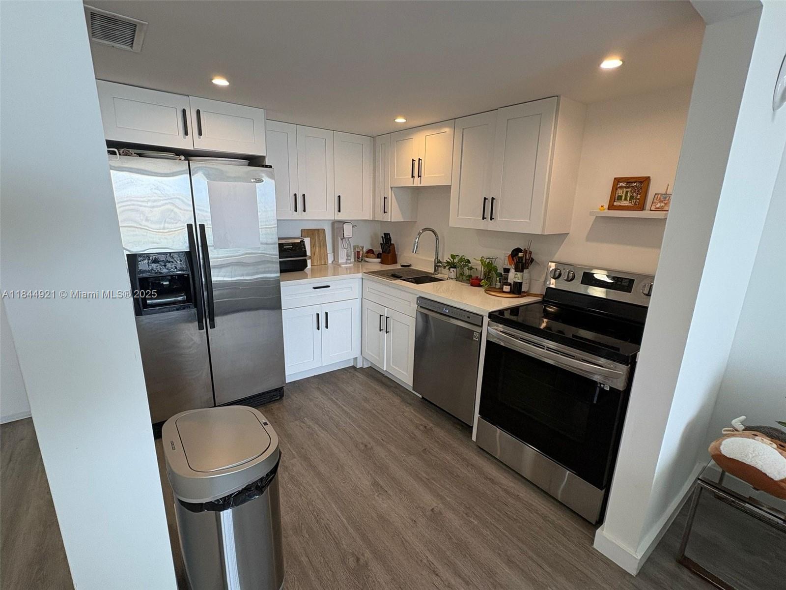 13499 Biscayne Boulevard, Unit 902 North Miami, FL 33181 - Photo 7 of 15 a kitchen with stainless steel appliances a stove a refrigerator and a sink