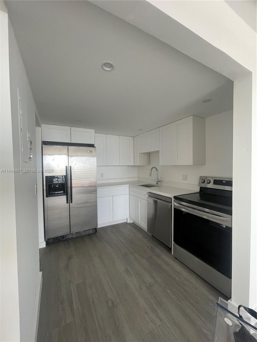 13499 Biscayne Boulevard, Unit 902 North Miami, FL 33181 - Photo 9 of 15 a kitchen with granite countertop a refrigerator and a stove top oven