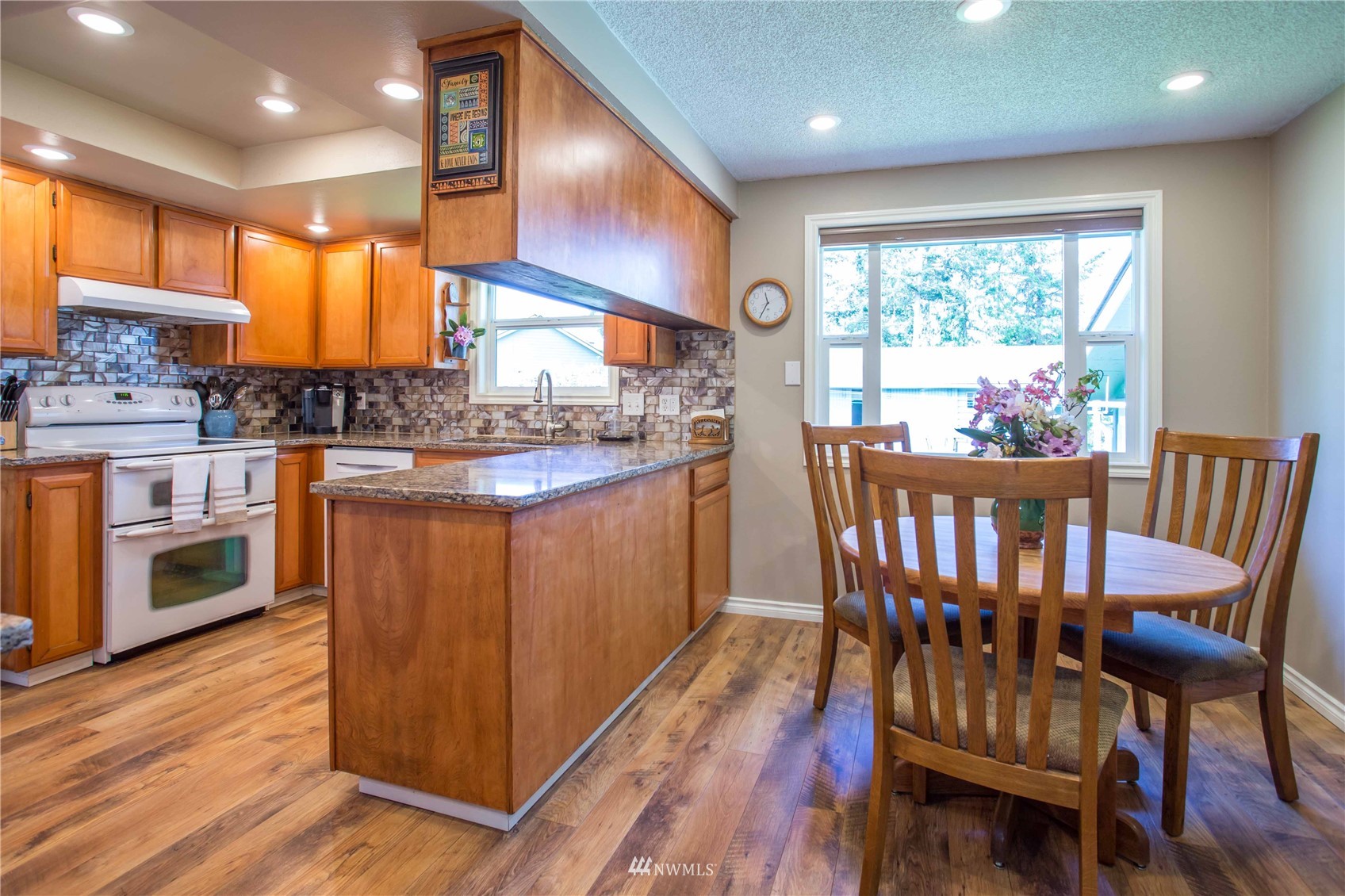 3951 Britton Road Bellingham, WA 98226 - Photo 12 of 39 a kitchen with stainless steel appliances granite countertop wooden floors and wooden cabinets
