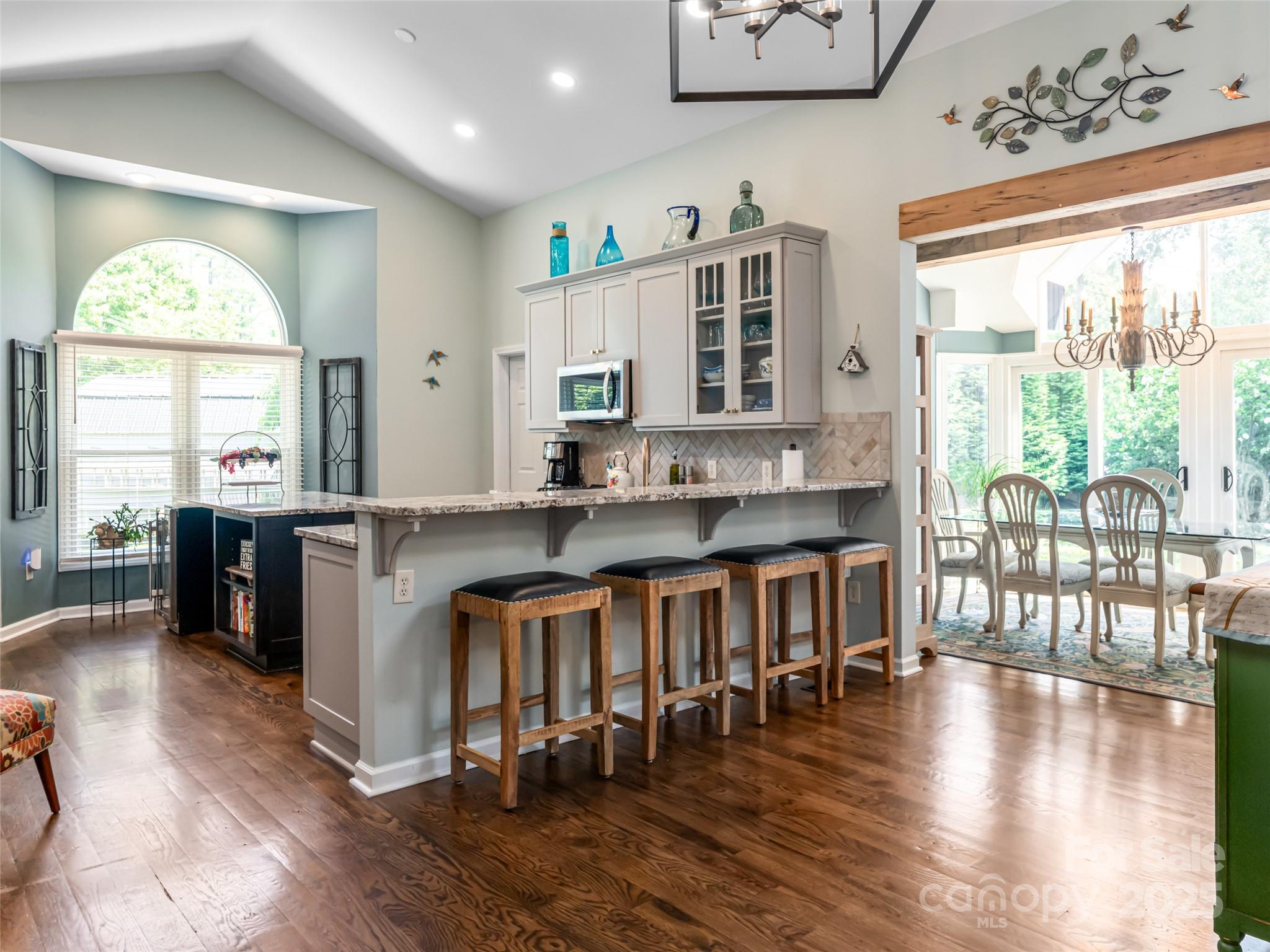 206 Pinner Road Arden, NC 28704 - Photo 12 of 47 an open kitchen with granite countertop a stove a sink a dining table and chairs with wooden floor