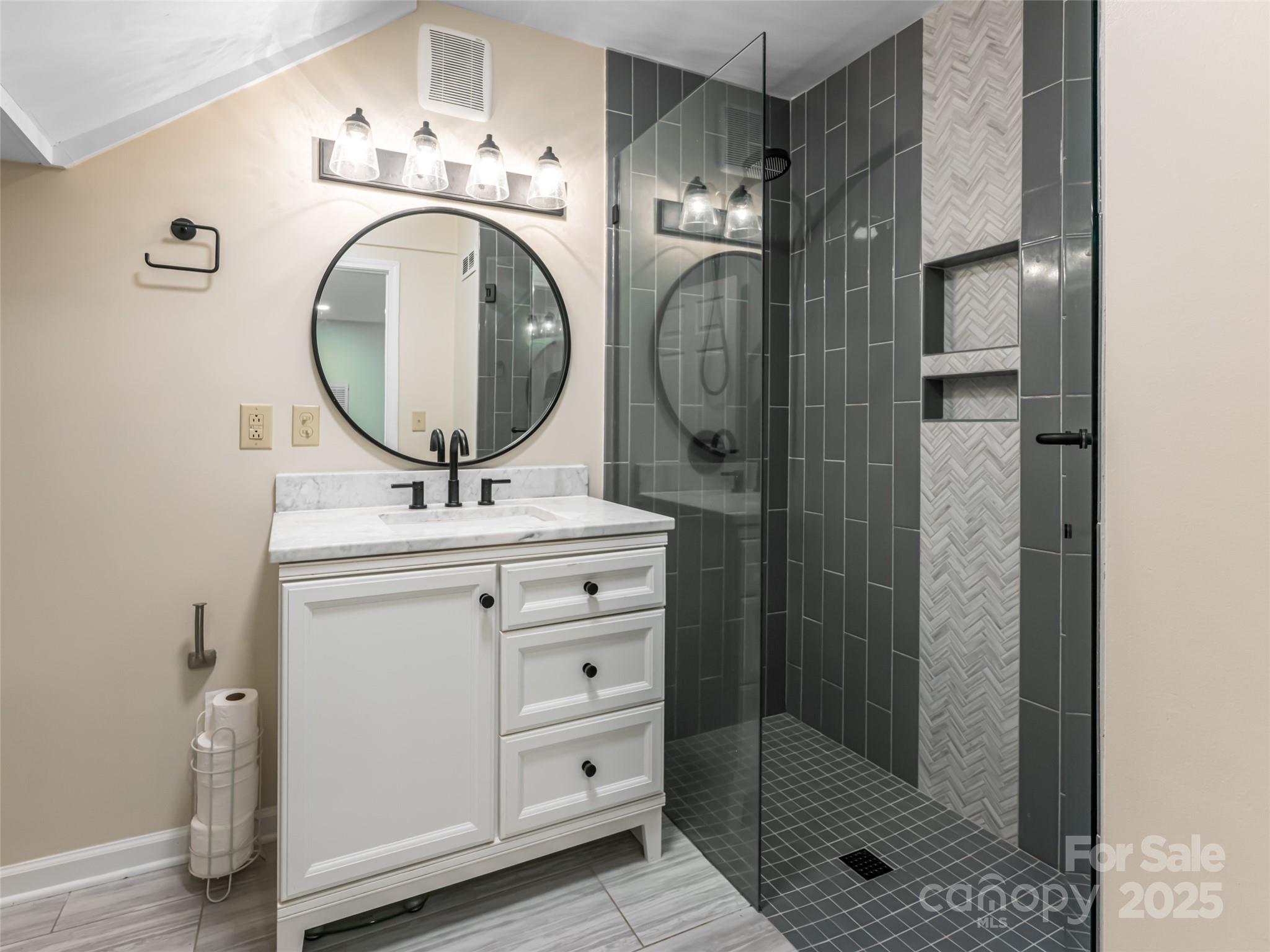 206 Pinner Road Arden, NC 28704 - Photo 25 of 47 a bathroom with a sink a mirror and shower