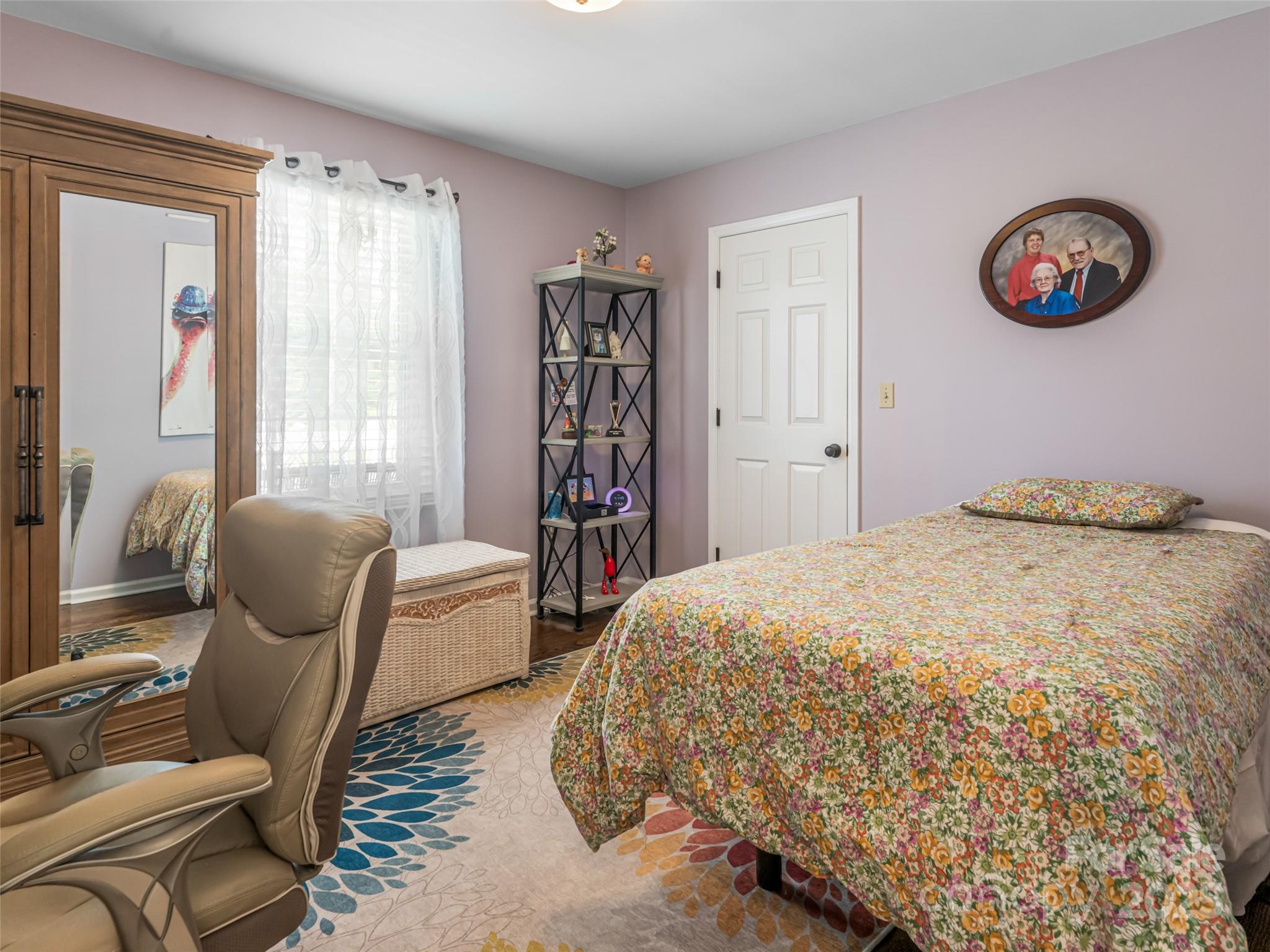 206 Pinner Road Arden, NC 28704 - Photo 27 of 47 a bedroom with a bed and dresser with wooden floor