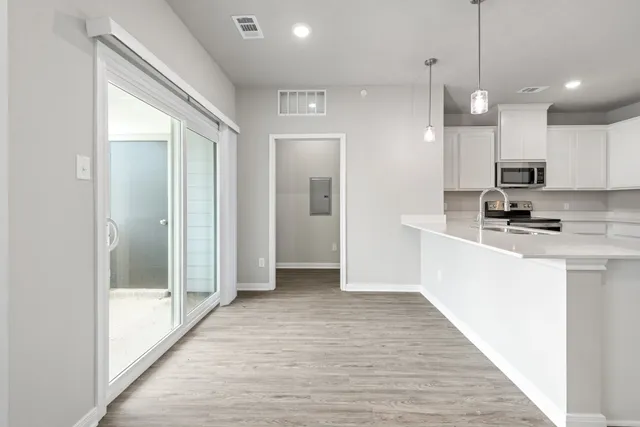 a kitchen with white cabinets and stainless steel appliances