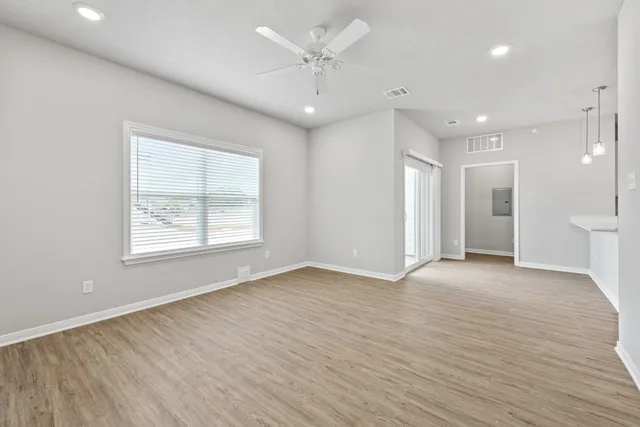 a view of a kitchen with kitchen island a sink wooden floor and floors
