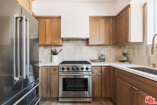 a kitchen with stainless steel appliances a stove a sink and a refrigerator