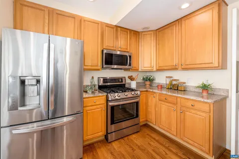 a kitchen with stainless steel appliances granite countertop a refrigerator stove top oven and sink