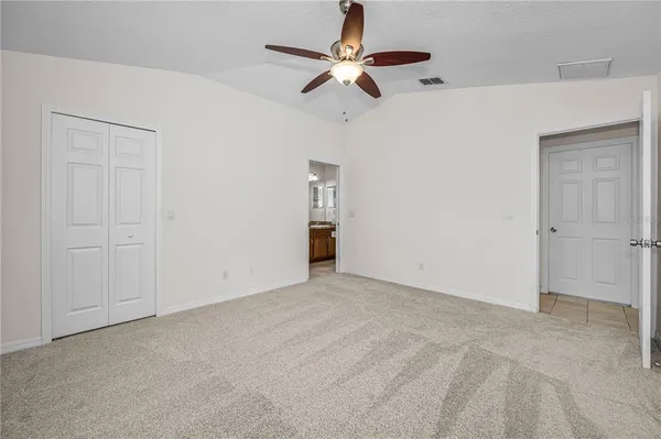 an empty room with a window and a ceiling fan