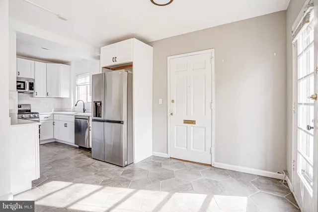 a kitchen with stainless steel appliances granite countertop white cabinets a sink and a stove