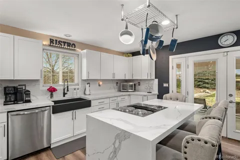 a kitchen with stainless steel appliances granite countertop a stove and a view of living room