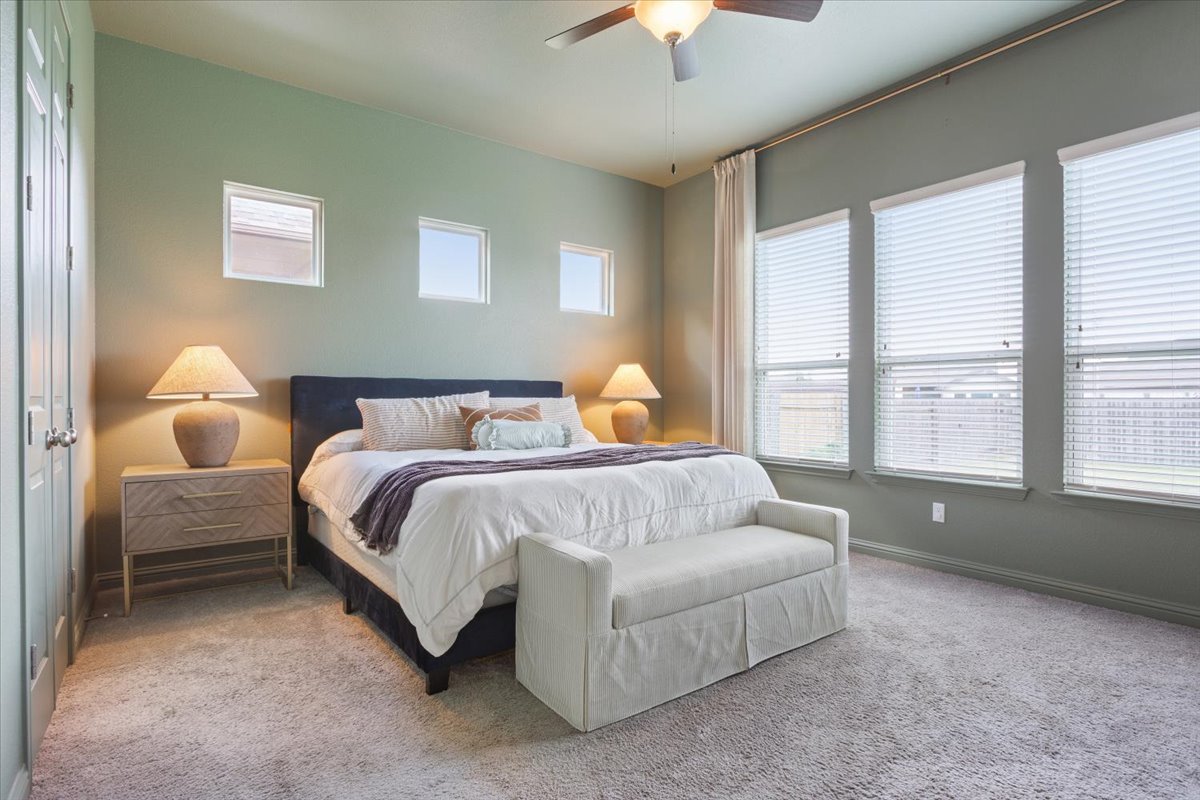 424 Millard Street Georgetown, TX 78628 - Photo 16 of 37 Well-lit sleeping quarters with plush carpeting and natural illumination through ample windows.