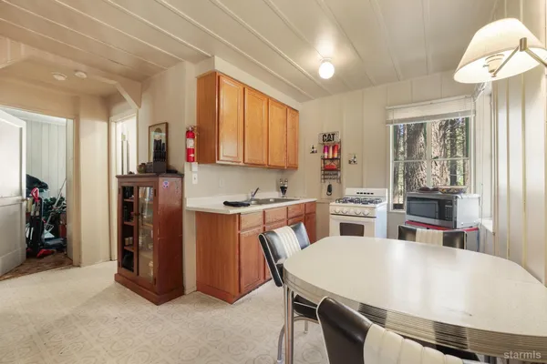 a kitchen with stainless steel appliances a dining table chairs and a refrigerator