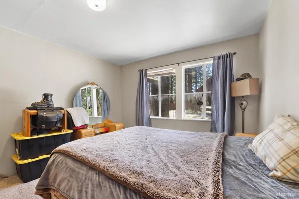 a bed sitting in a bedroom next to a window