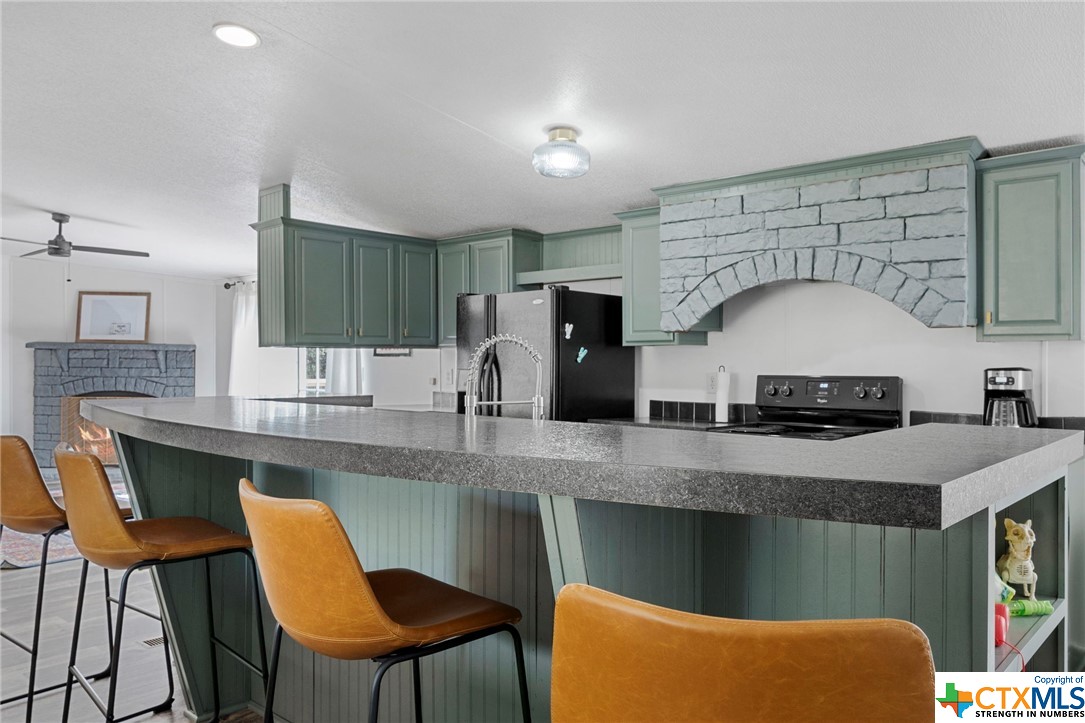 a kitchen with stainless steel appliances granite countertop a table chairs sink and microwave