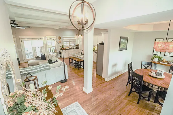 a view of a patio with dining table and chairs potted plants and a big yard
