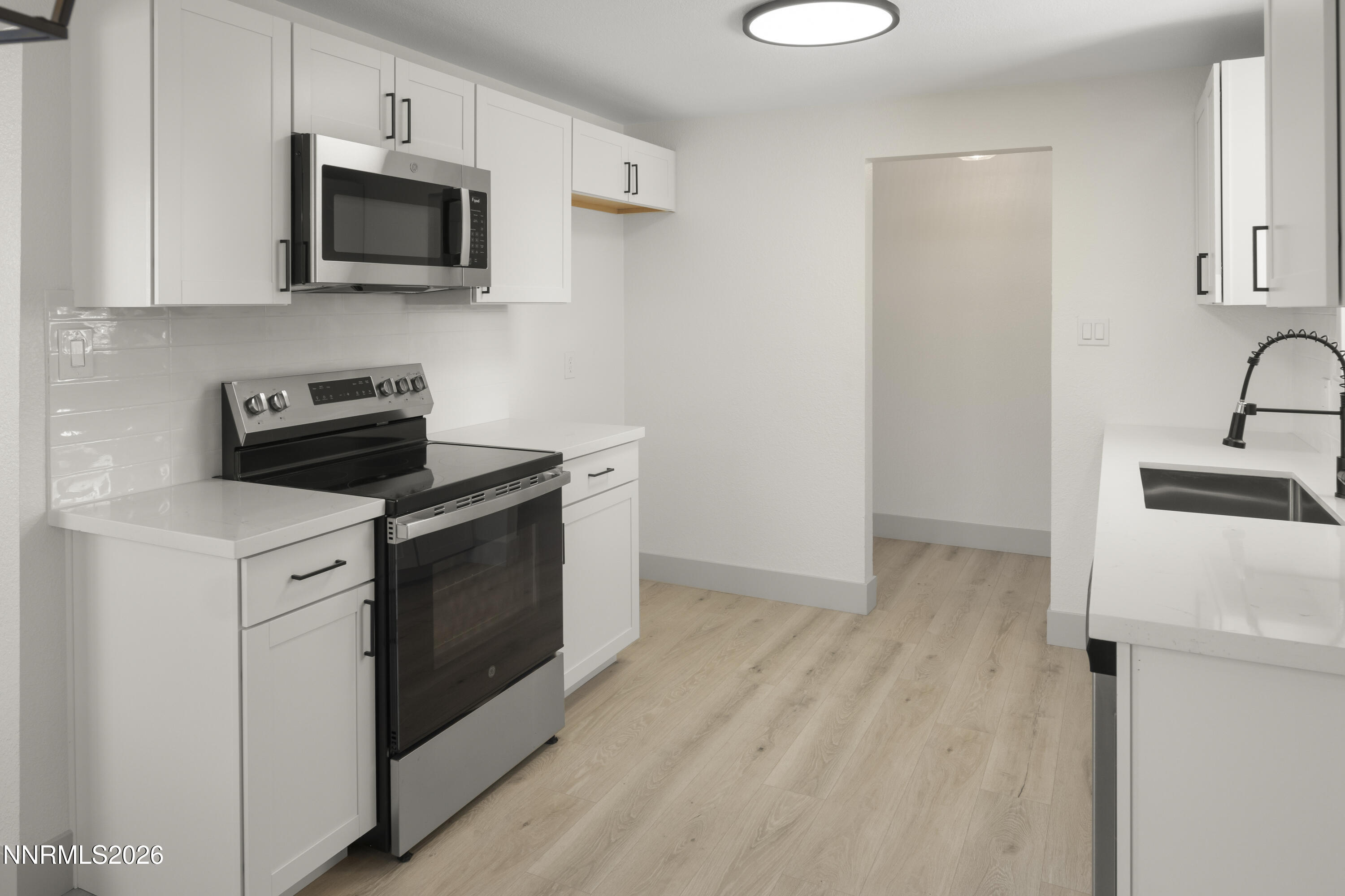 308 Shawna Way Yerington, NV 89447 - Photo 12 of 37 a kitchen with stainless steel appliances a stove microwave and sink