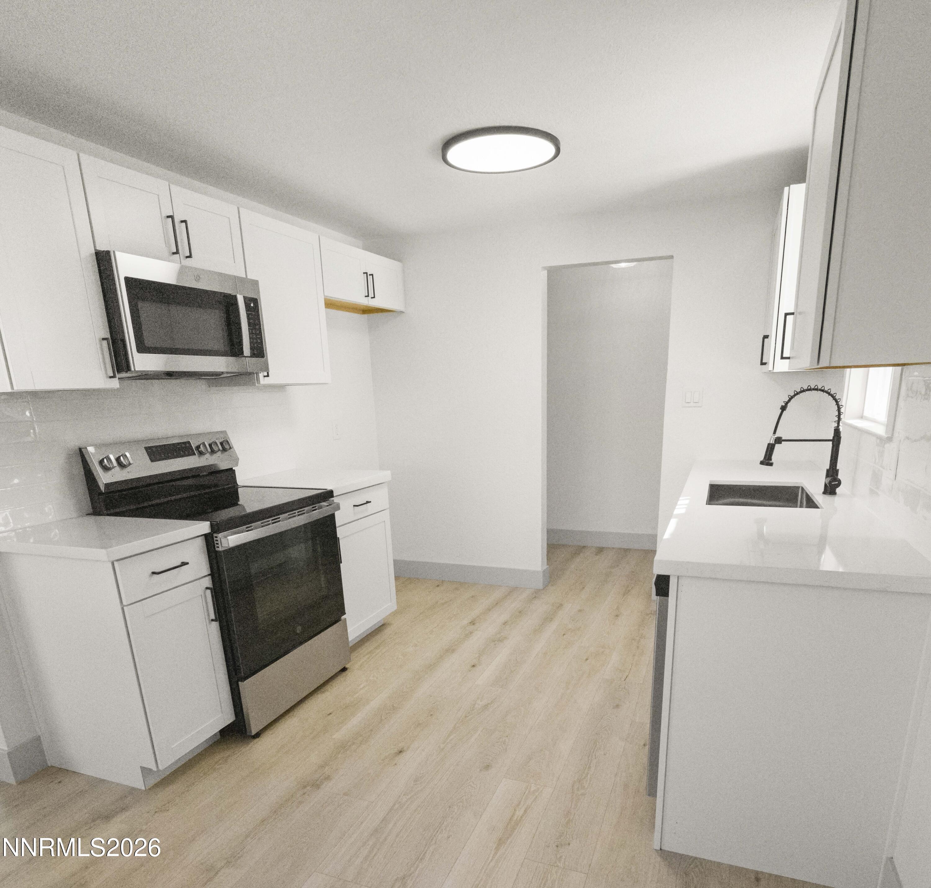 308 Shawna Way Yerington, NV 89447 - Photo 6 of 37 a kitchen with stainless steel appliances a stove microwave and sink