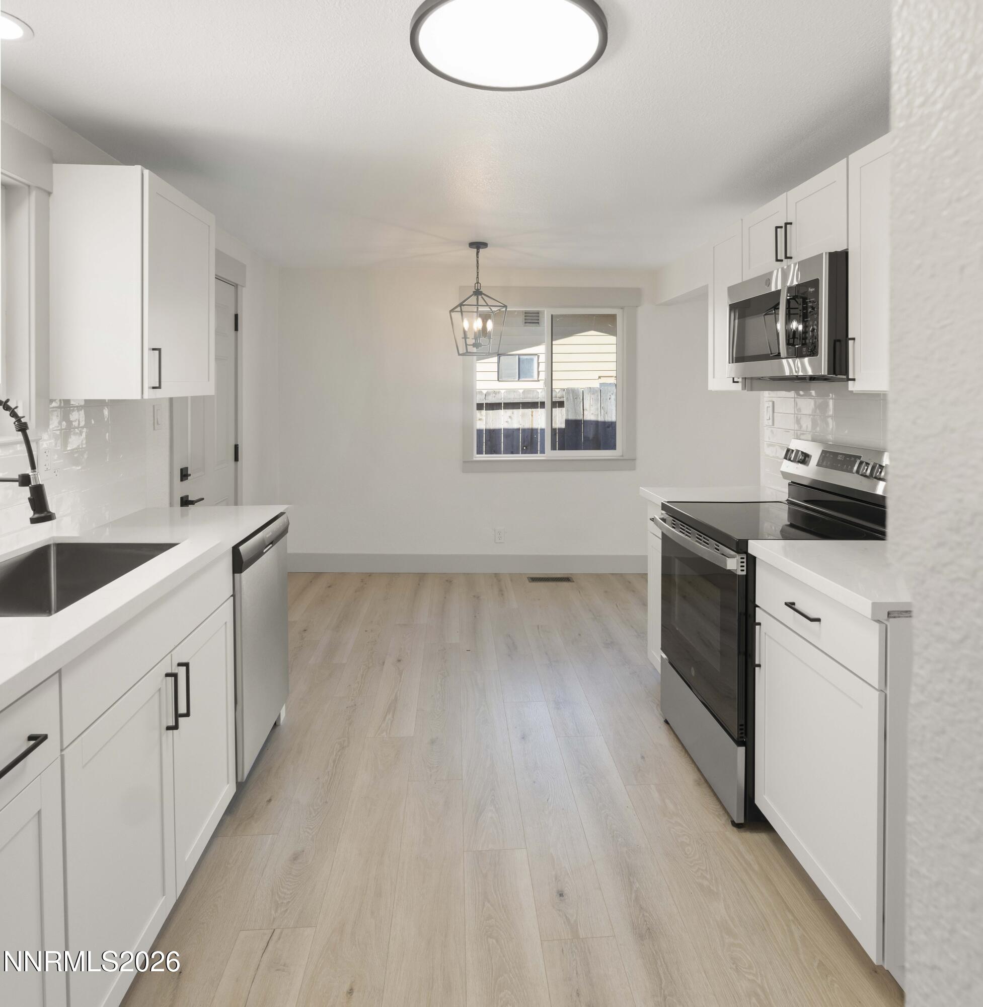 308 Shawna Way Yerington, NV 89447 - Photo 8 of 37 a kitchen with a sink wooden floor and white appliances