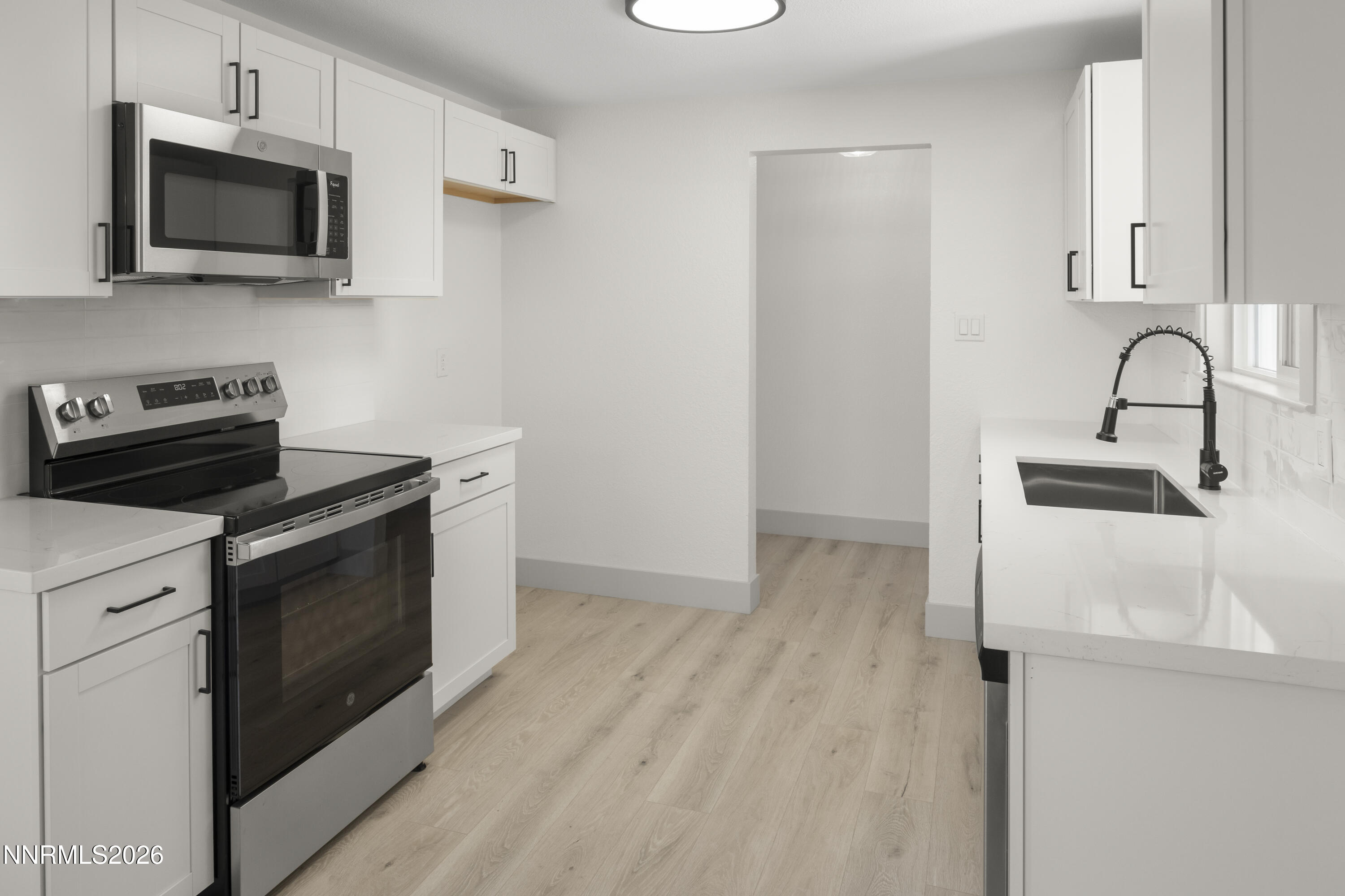 308 Shawna Way Yerington, NV 89447 - Photo 9 of 37 a kitchen with stainless steel appliances a stove microwave and sink