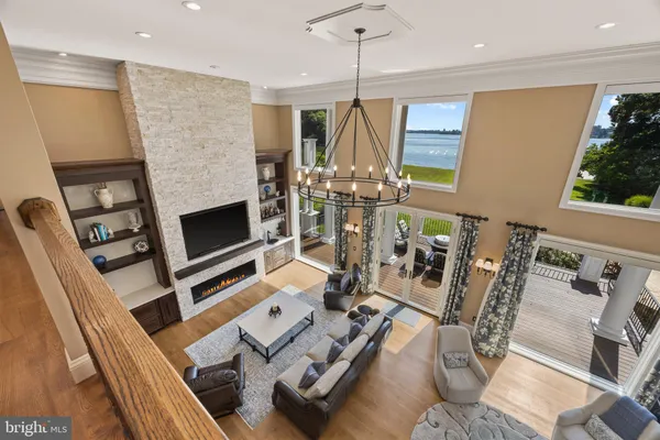 a living room with furniture a flat screen tv and a floor to ceiling window