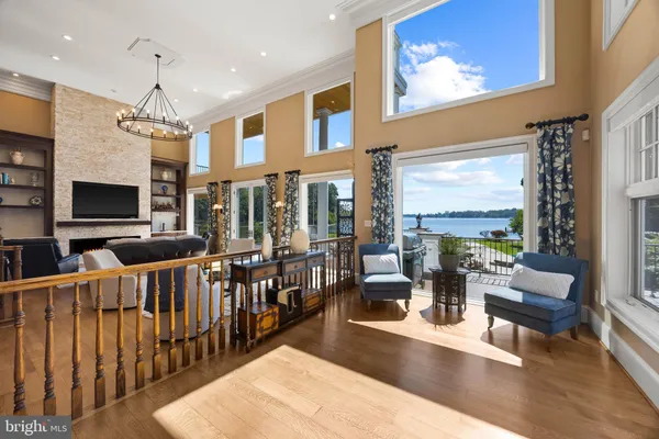 a living room with furniture a flat screen tv and floor to ceiling window