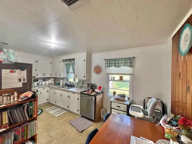 a kitchen with a stove a sink and a refrigerator with wooden floor