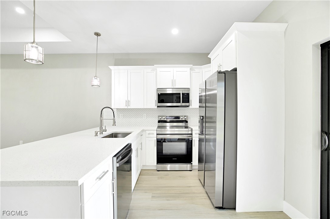 4846 30th Street Southwest Lehigh Acres, FL 33973 - Photo 14 of 14 a kitchen with stainless steel appliances a stove a sink and a refrigerator