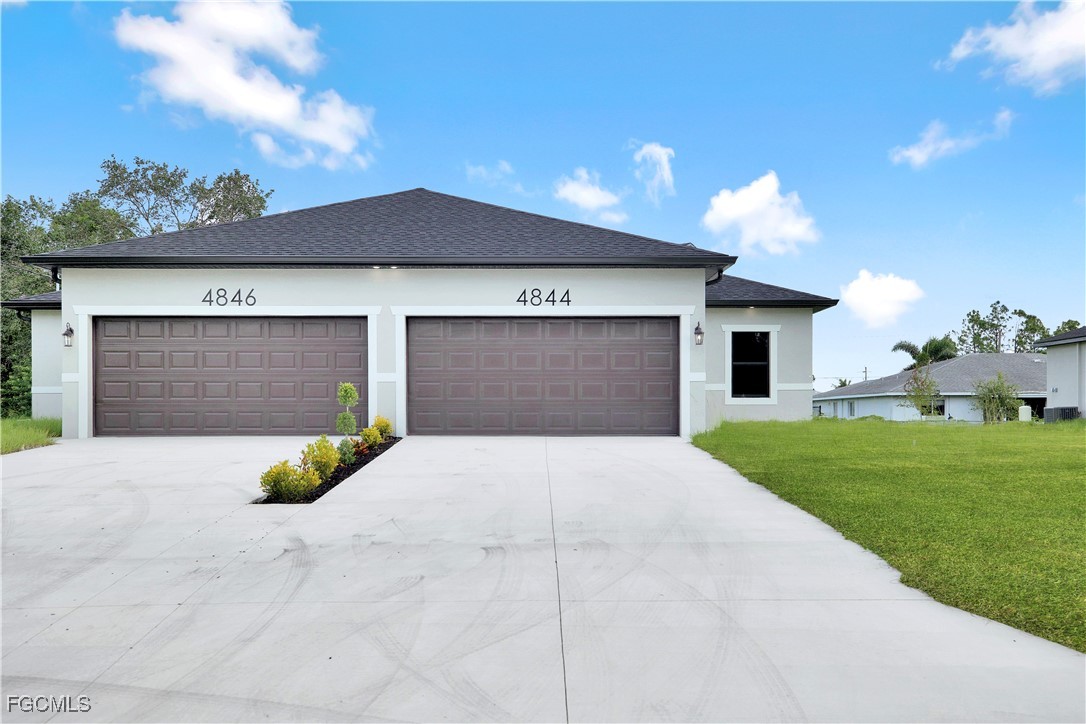 4846 30th Street Southwest Lehigh Acres, FL 33973 - Photo 5 of 14 a front view of a house with a yard and garage