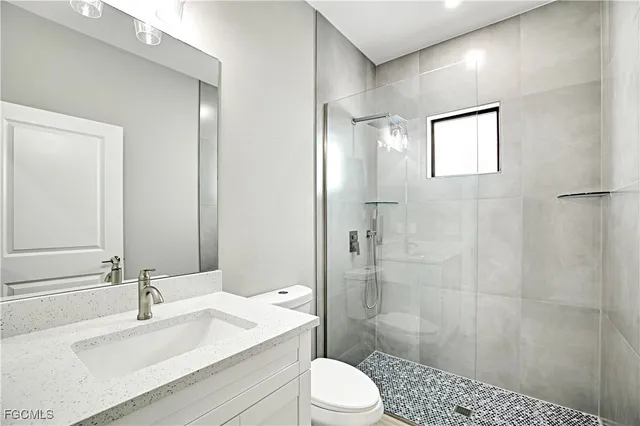 an empty room with wooden floor and ceiling fan