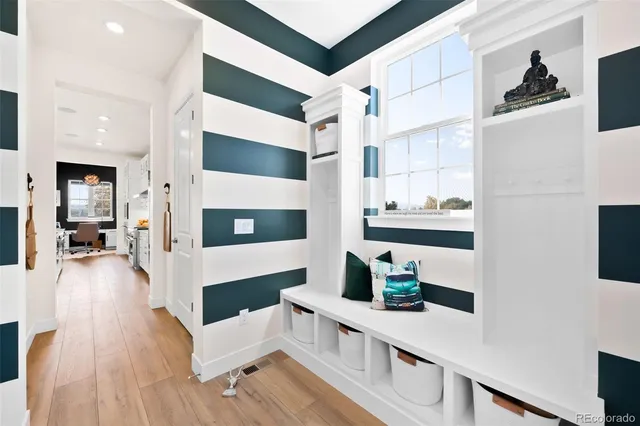 a hallway with white cabinets and wooden floor