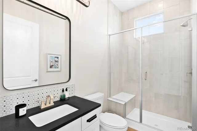 a bathroom with a sink vanity mirror and toilet