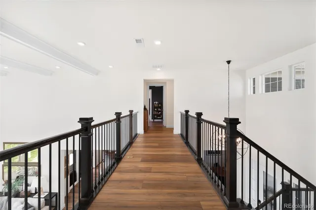 a view of a hallway with wooden floor and stairs