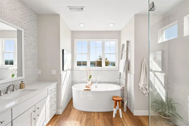 a bathroom with a granite countertop sink mirror and a bathtub