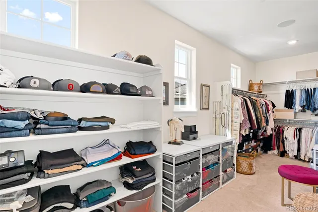 a view of walk in closet with clothes and shoes