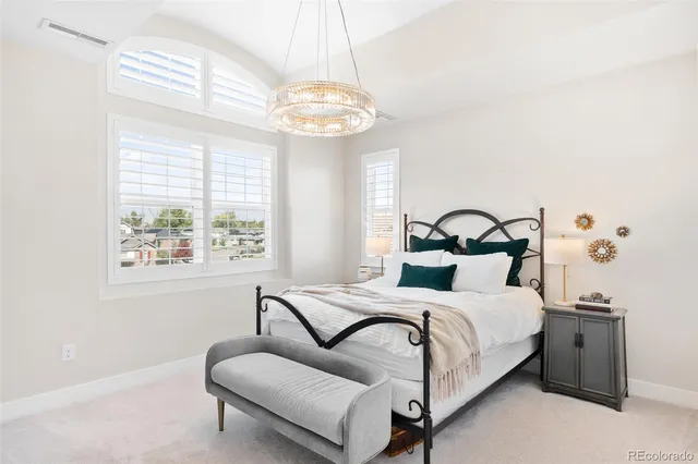 a bedroom with a bed and a chandelier