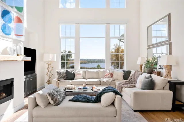 a living room with furniture a large window and a fireplace